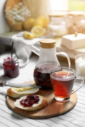 Photo of Aromatic tea and slicebread with jam on table