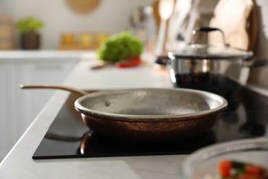 Frying pan on modern cooktop in kitchen