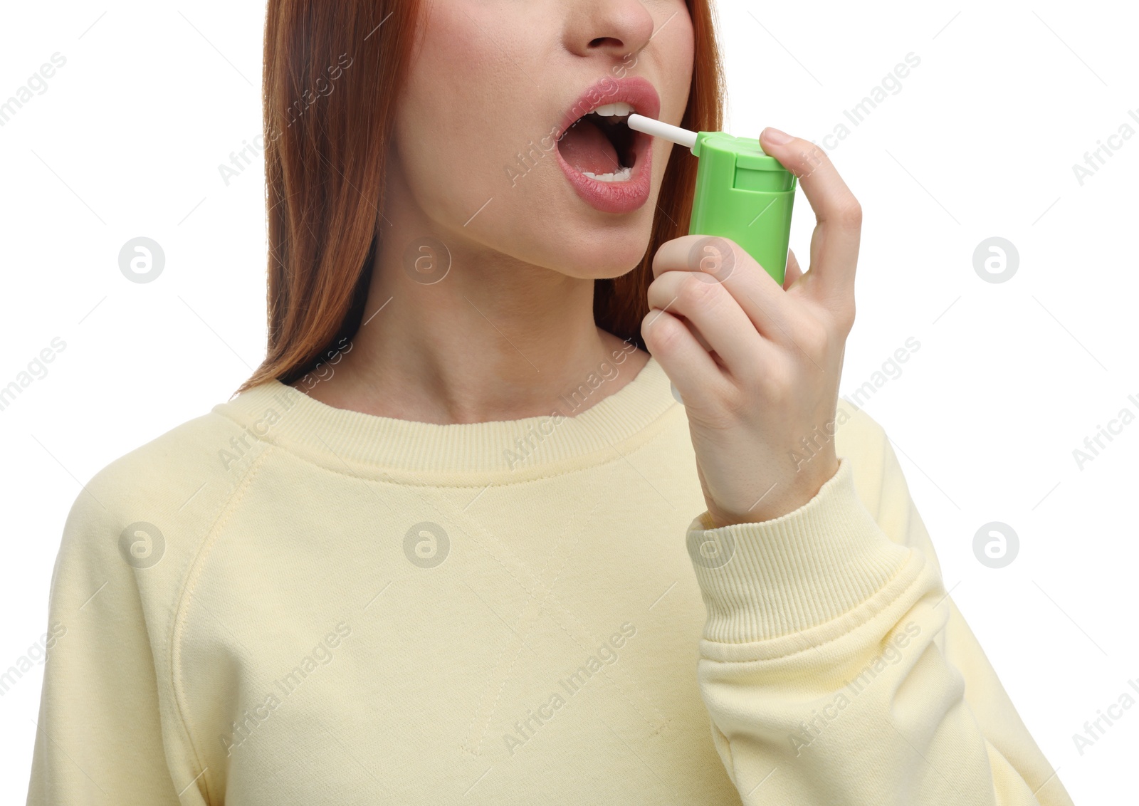 Photo of Young woman using throat spray on white background, closeup