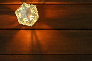 Decorative Arabic lantern on wooden table, top view. Space for text