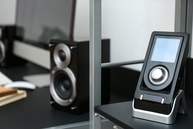 Photo of Modern audio speaker and remote control indoors