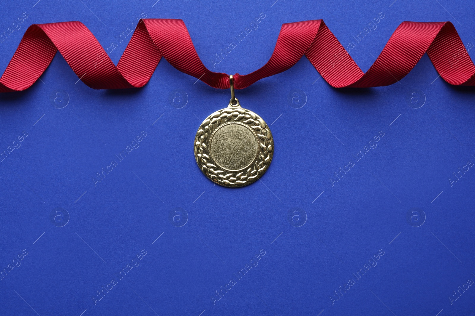 Photo of Gold medal with space for design on color background, top view. Victory concept