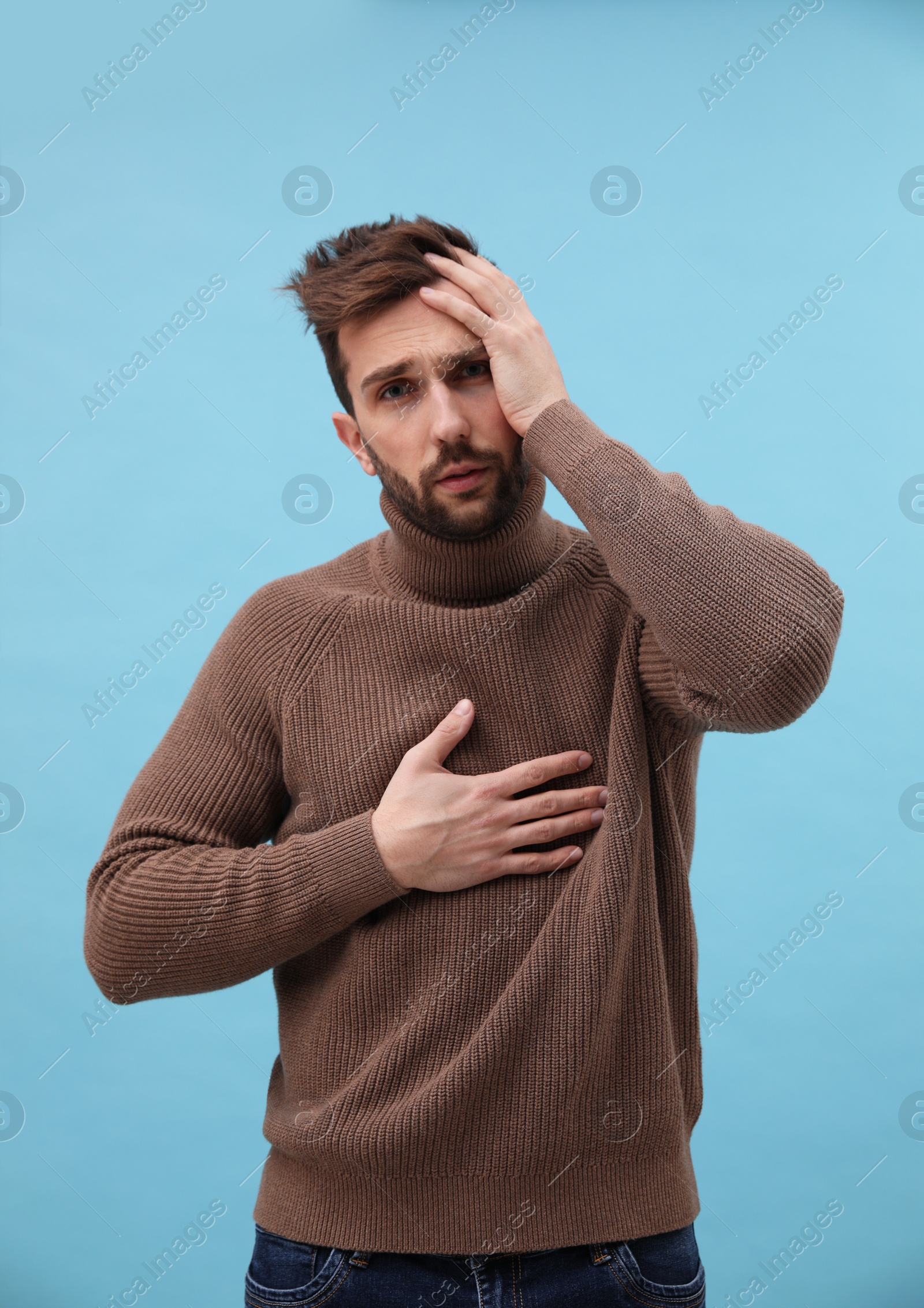 Photo of Man suffering from cold on light blue background