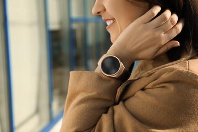 Mature woman with smart watch outdoors, closeup