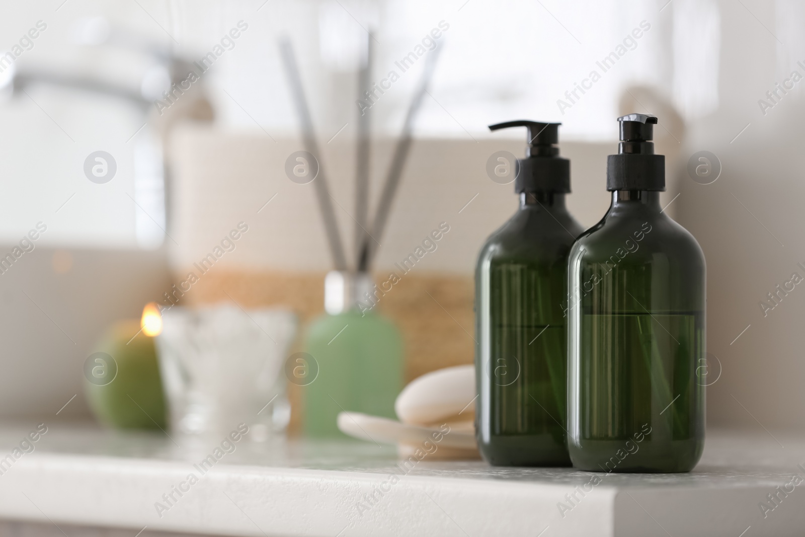 Photo of Green soap dispensers on countertop near sink in bathroom. Space for text