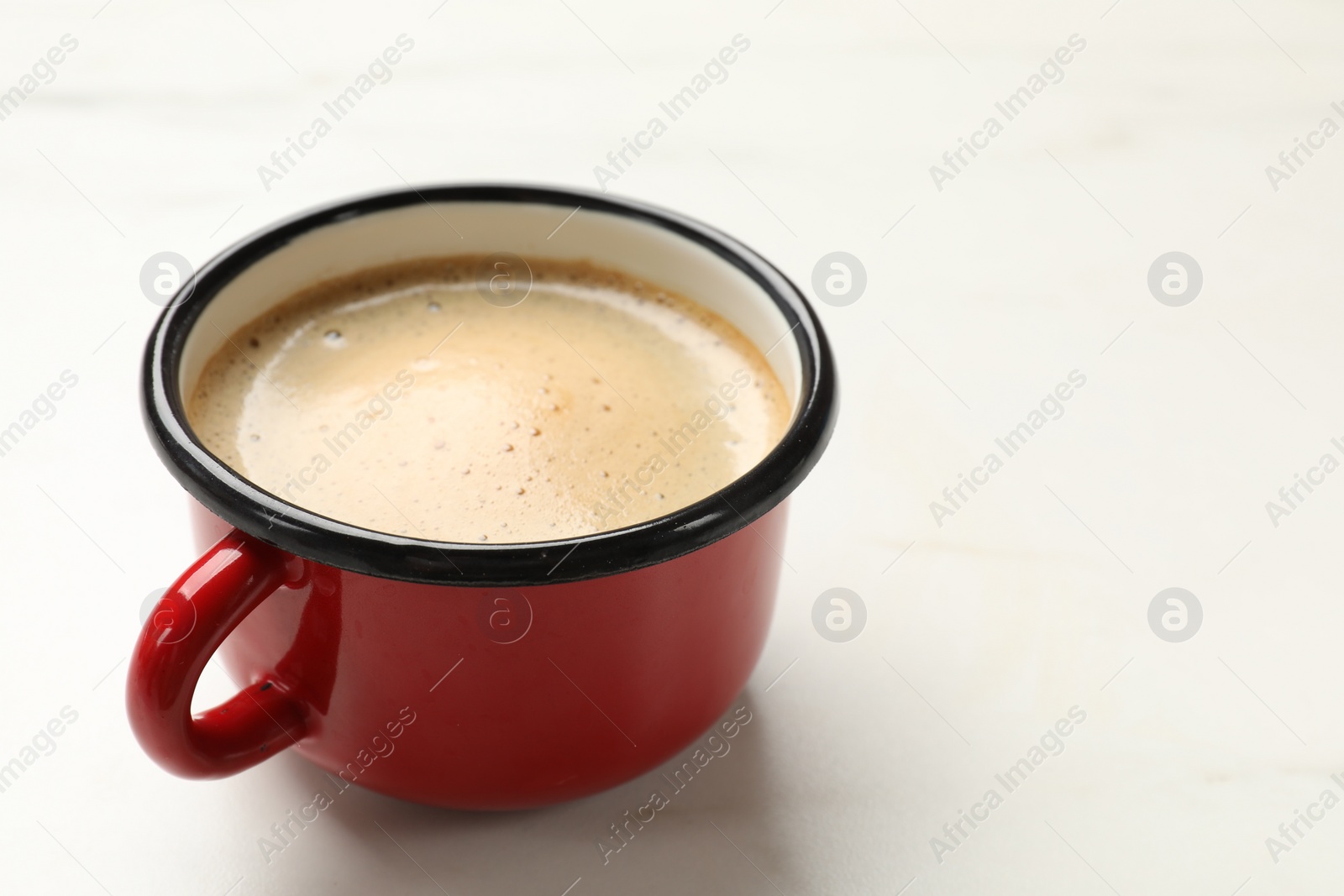 Photo of Cup of aromatic coffee on white table, closeup. Space for text