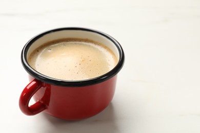 Photo of Cup of aromatic coffee on white table, closeup. Space for text