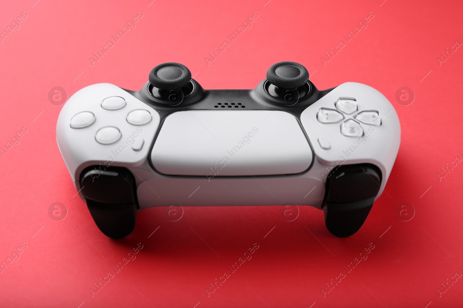 Photo of One wireless game controller on red background