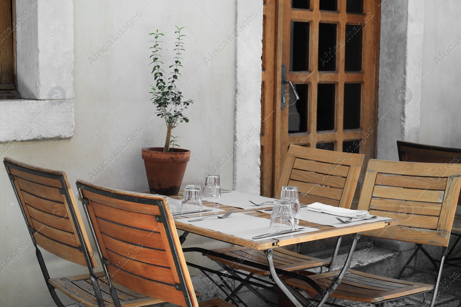 Photo of Outdoor cafe with wooden chairs and table