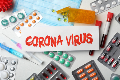 Photo of Flat lay composition with phrase CORONA VIRUS and medicines on white background