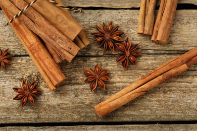 Photo of Cinnamon sticks and star anise on wooden table, flat lay