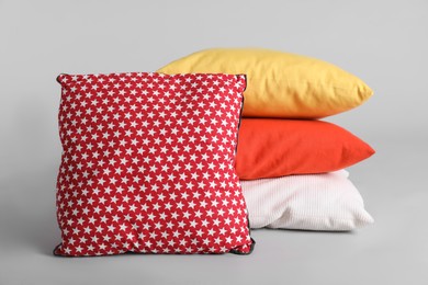 Different stylish soft pillows on grey background