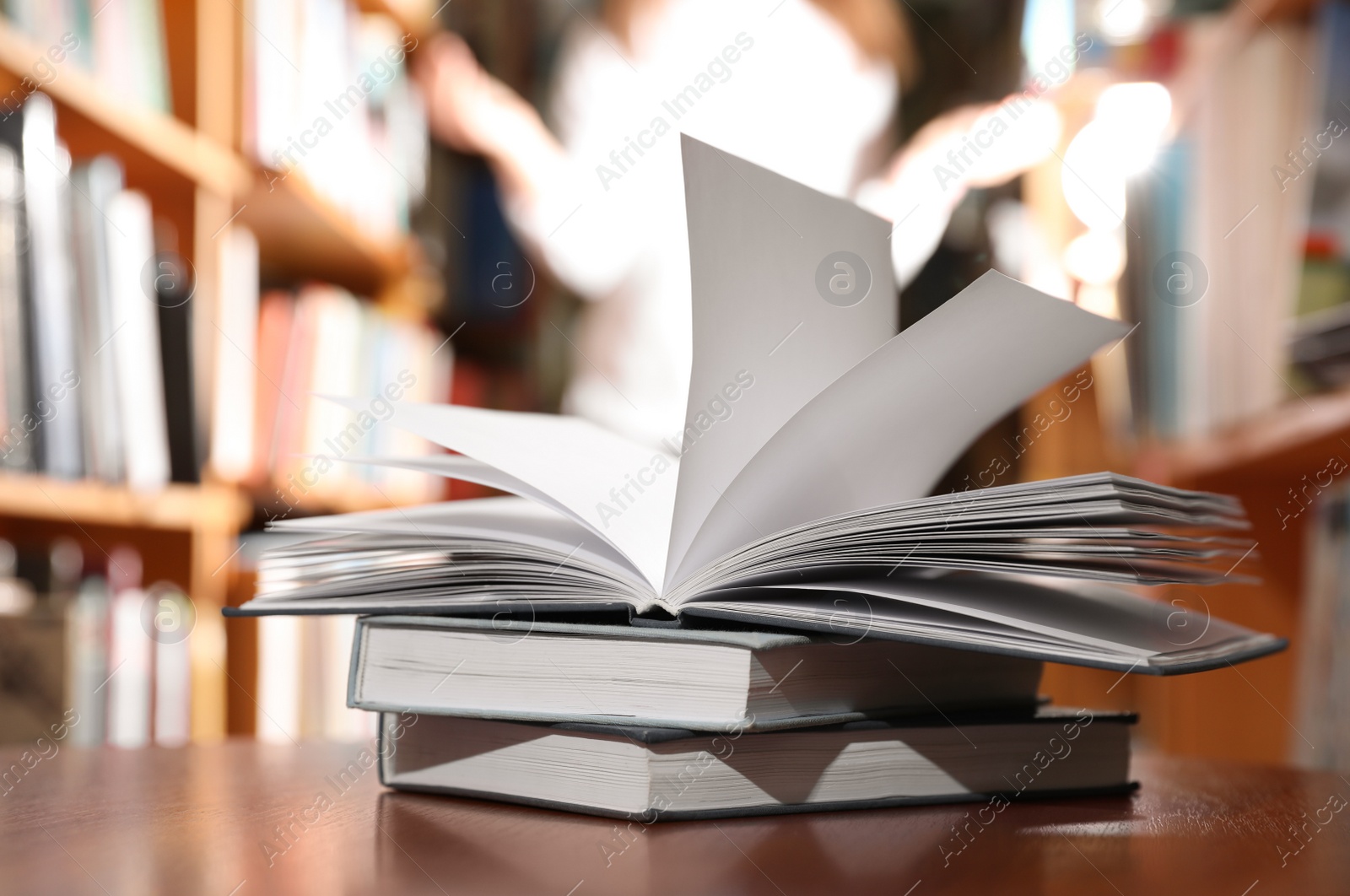 Photo of Stack of books on table in library