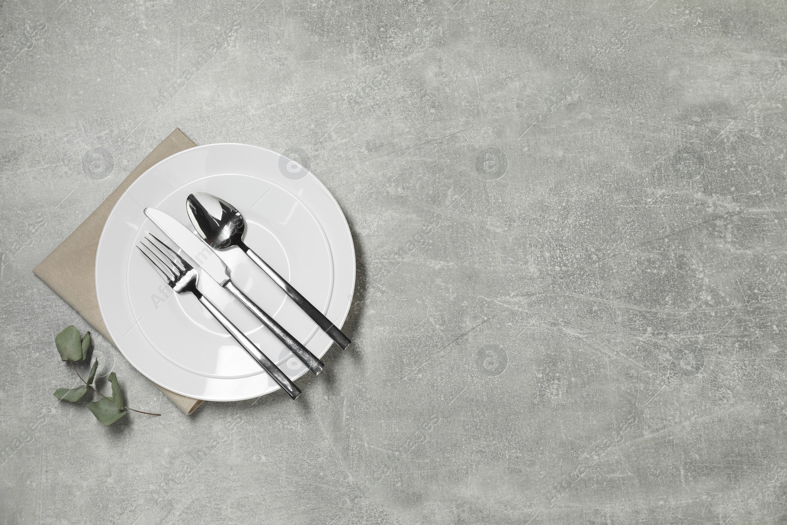 Photo of Stylish setting with elegant cutlery on grey table, top view. Space for text