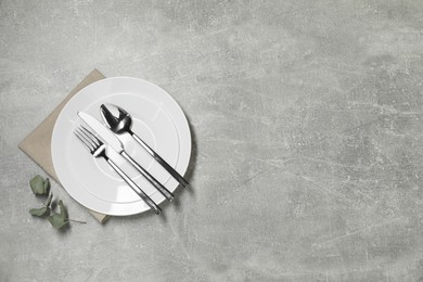 Photo of Stylish setting with elegant cutlery on grey table, top view. Space for text