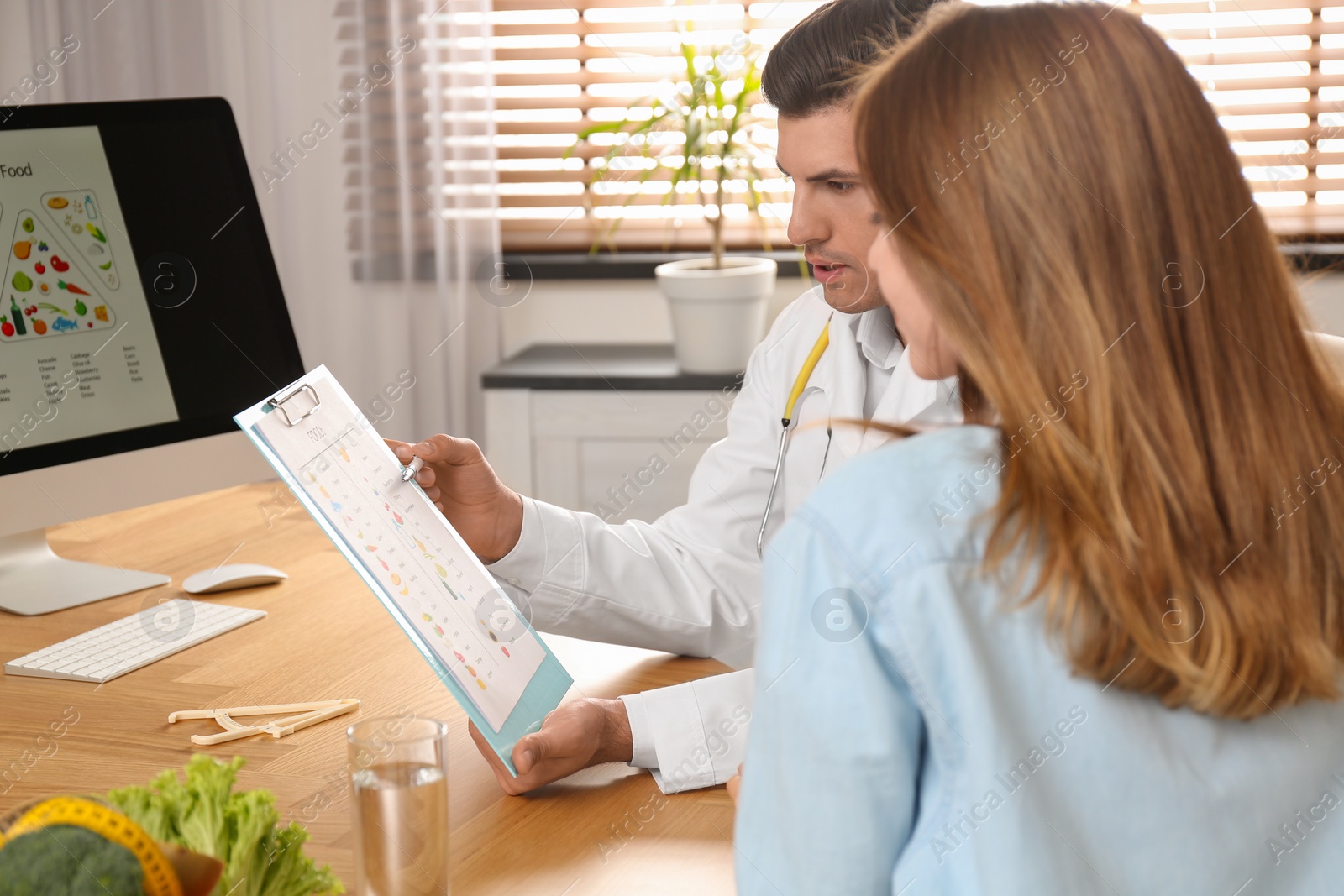 Photo of Nutritionist consulting patient at table in clinic