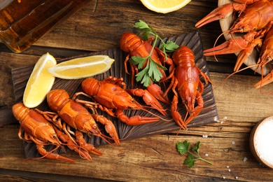 Photo of Flat lay composition with delicious red boiled crayfishes on wooden table