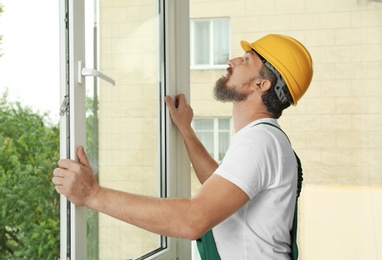 Photo of Construction worker installing new window in house