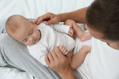 Photo of Father with his cute sleeping baby on bed, above view