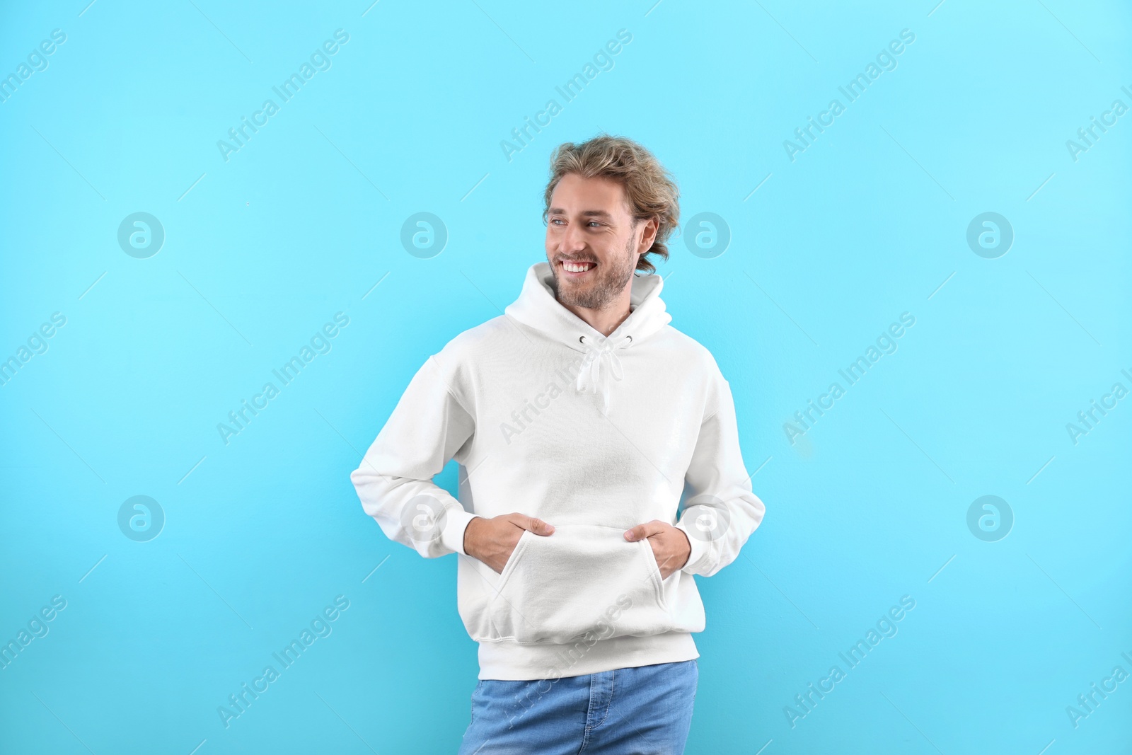 Photo of Portrait of man in hoodie sweater on color background. Space for design