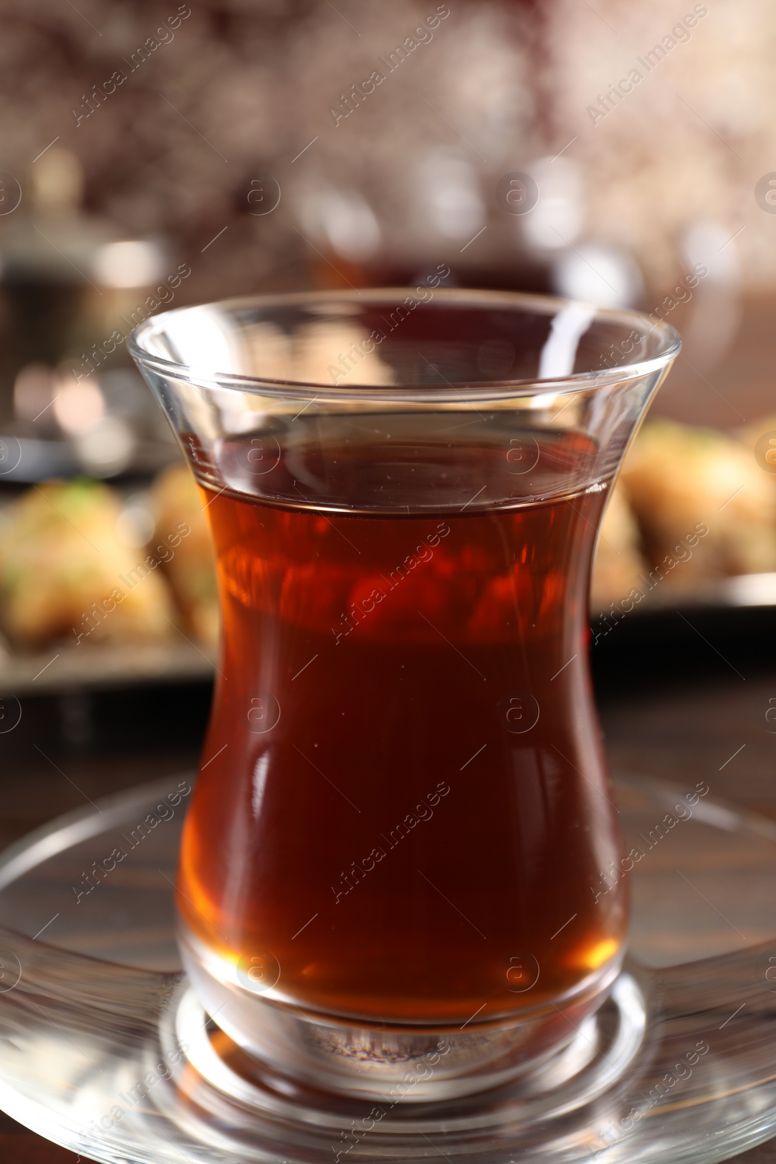 Photo of Traditional Turkish tea in glass on table, closeup