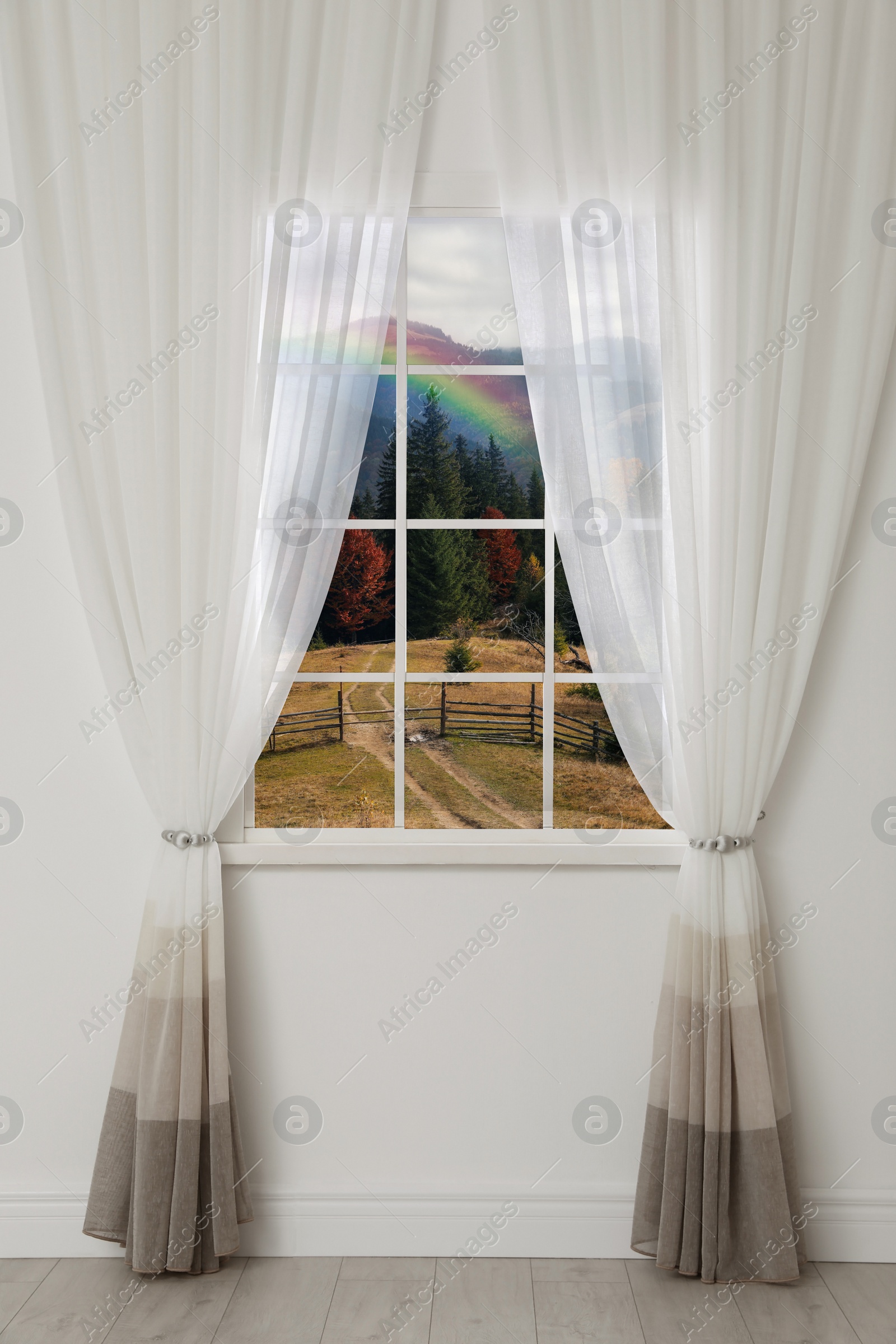 Image of View of beautiful rainbow in mountains through window