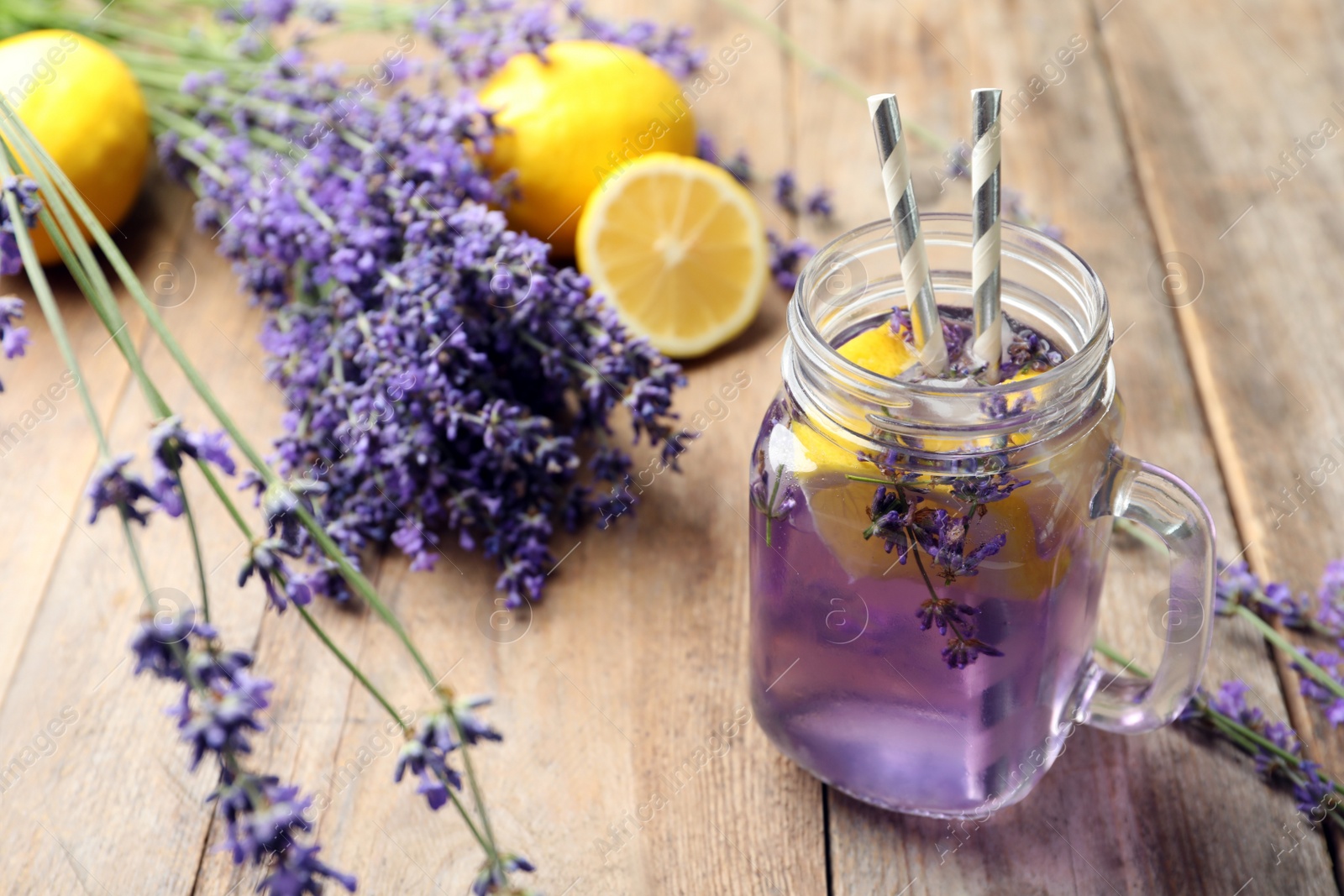 Photo of Fresh delicious lemonade with lavender in masson jar on wooden table