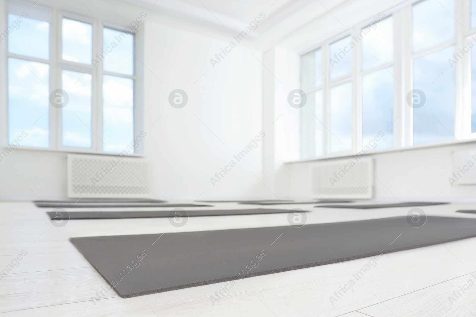 Photo of Spacious yoga studio with exercise mats and big windows, low angle view