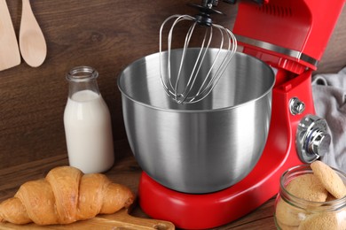 Modern red stand mixer, croissant and cookies on wooden table, closeup