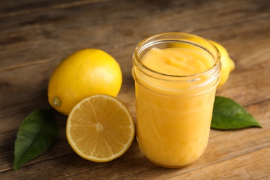 Photo of Delicious lemon curd and fresh fruits on wooden table