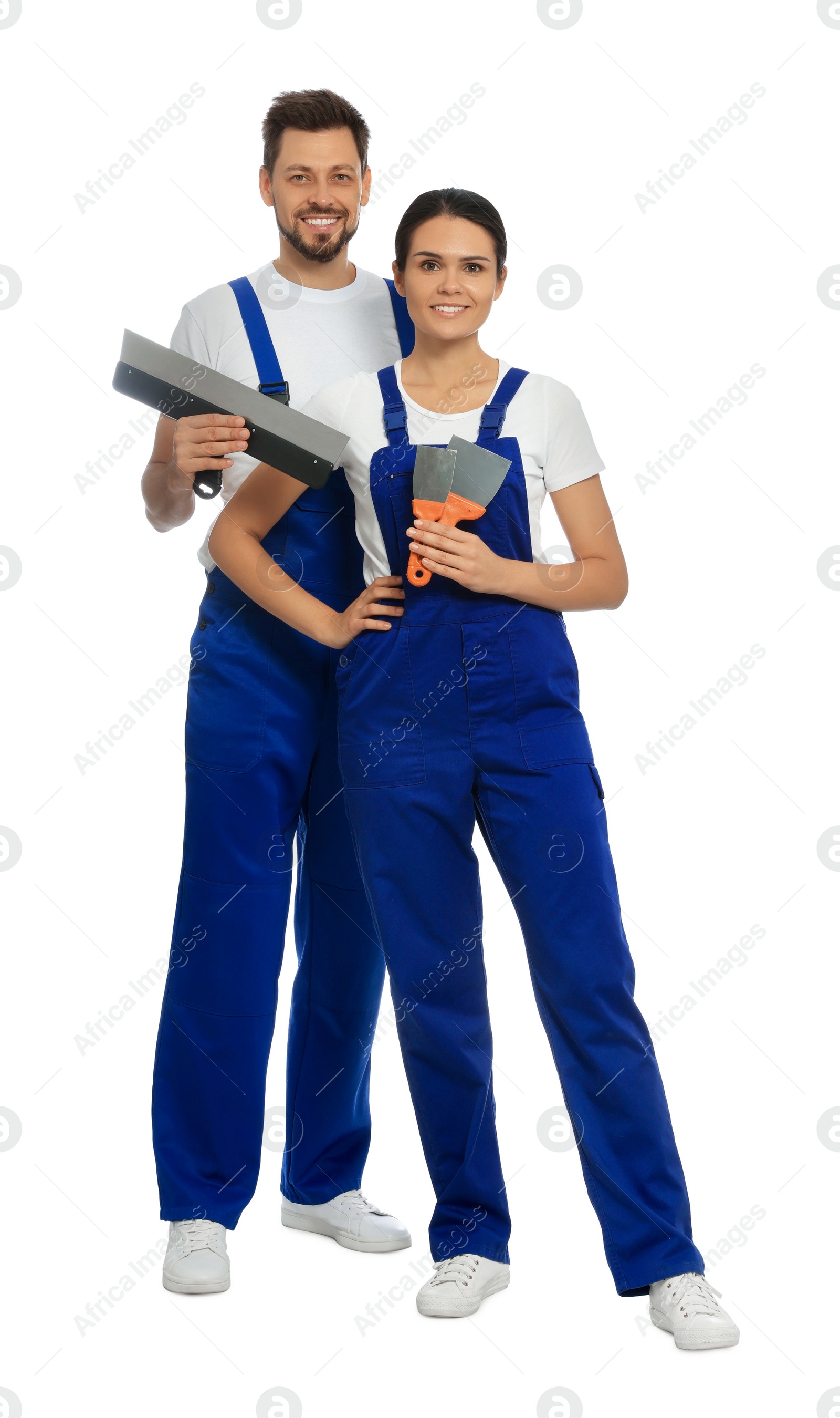 Photo of Professional workers in uniform with putty knives on white background