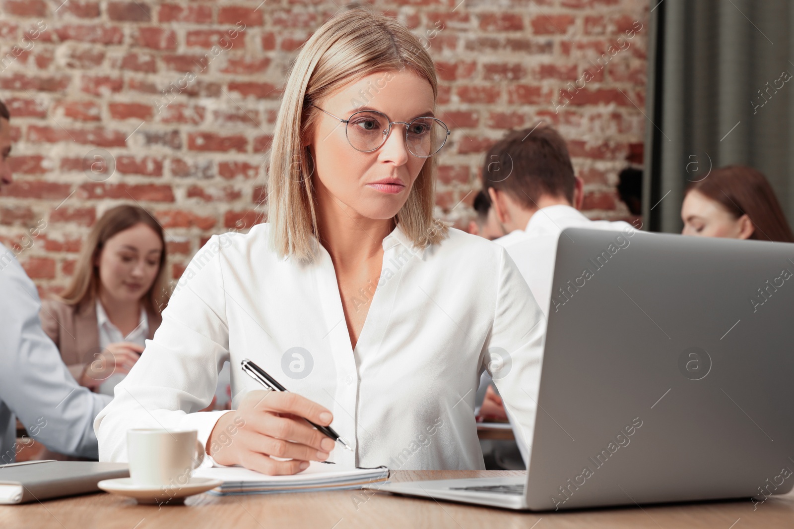 Photo of Businesswoman and her employees in office. Lady boss