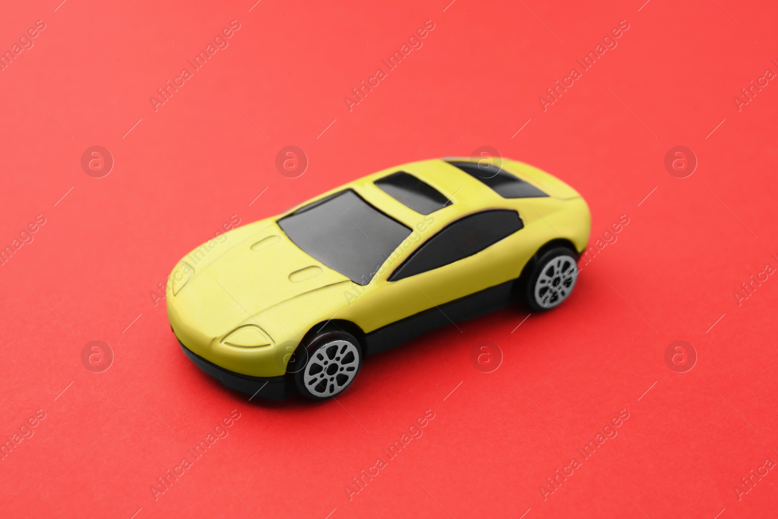 Photo of One yellow car on red background. Children`s toy