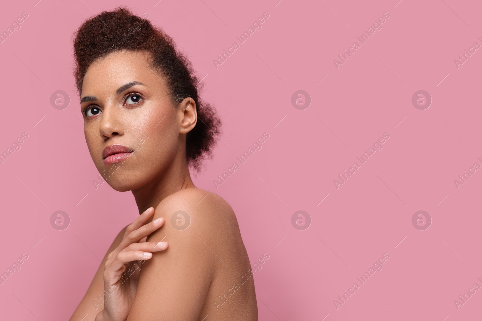 Photo of Portrait of beautiful young woman with glamorous makeup on pink background. Space for text