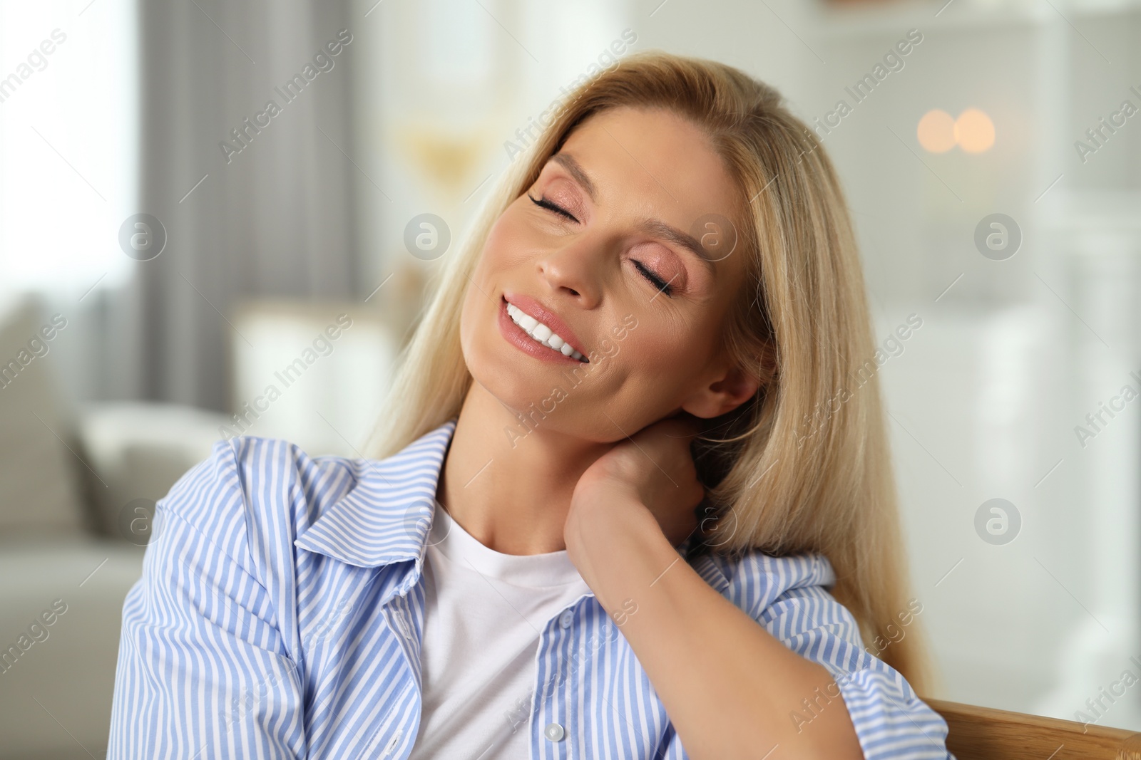 Photo of Portrait of smiling middle aged woman with blonde hair at home