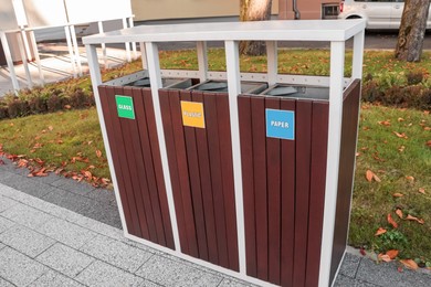 Different sorting bins for waste recycling on city street outdoors