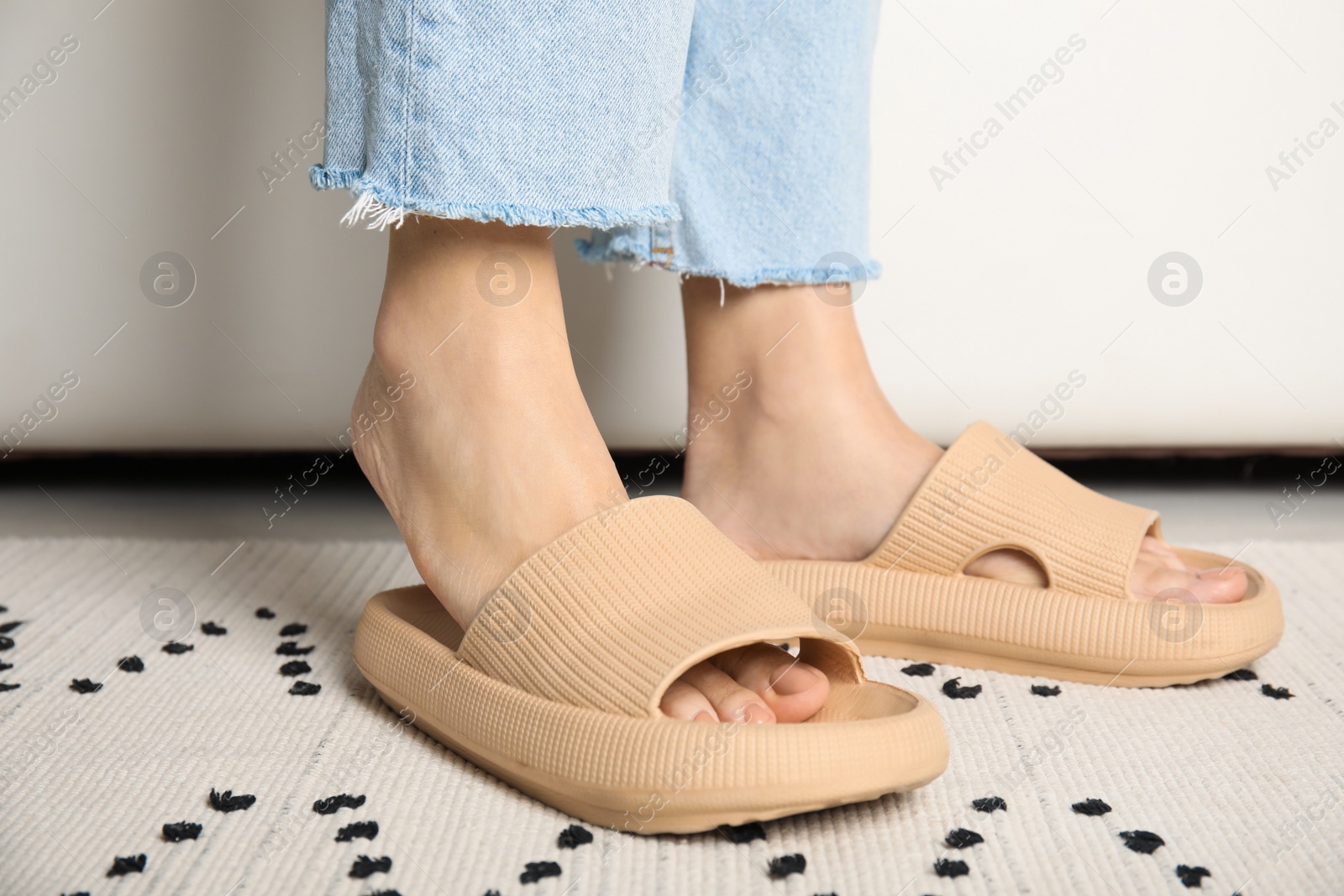 Photo of Woman wearing comfortable rubber slippers indoors, closeup