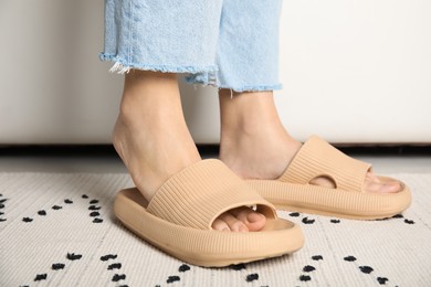 Woman wearing comfortable rubber slippers indoors, closeup