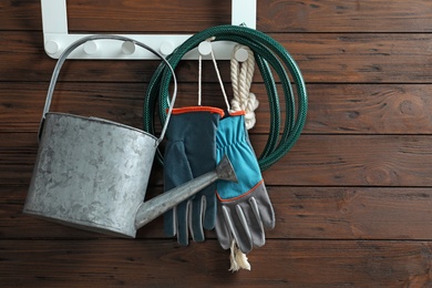 Photo of Set of professional gardening tools hanging on wooden wall