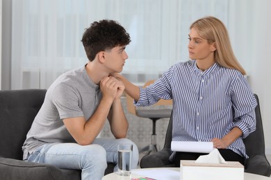 Photo of Psychologist working with teenage boy in office. Teenager problems