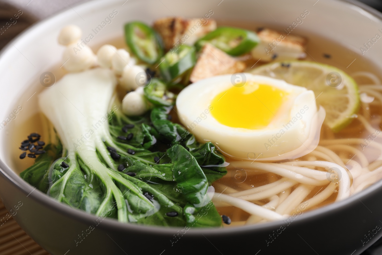 Photo of Bowl of vegetarian ramen on table, closeup