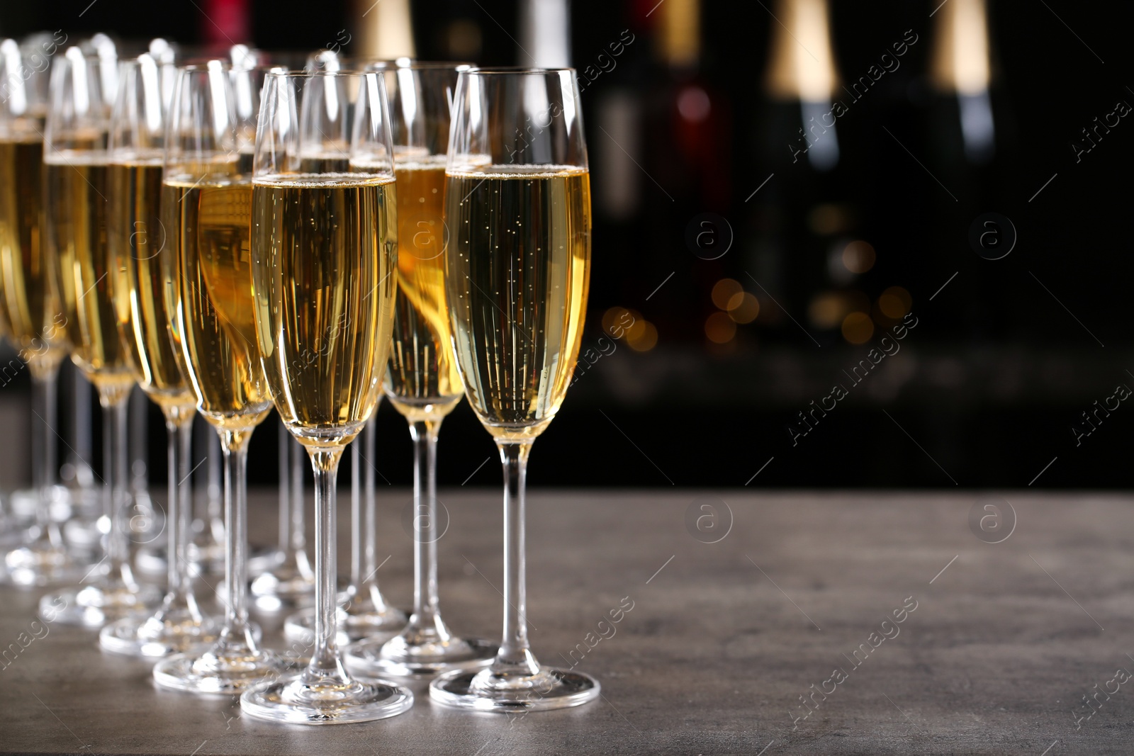 Photo of Glasses of champagne on table against blurred background. Space for text
