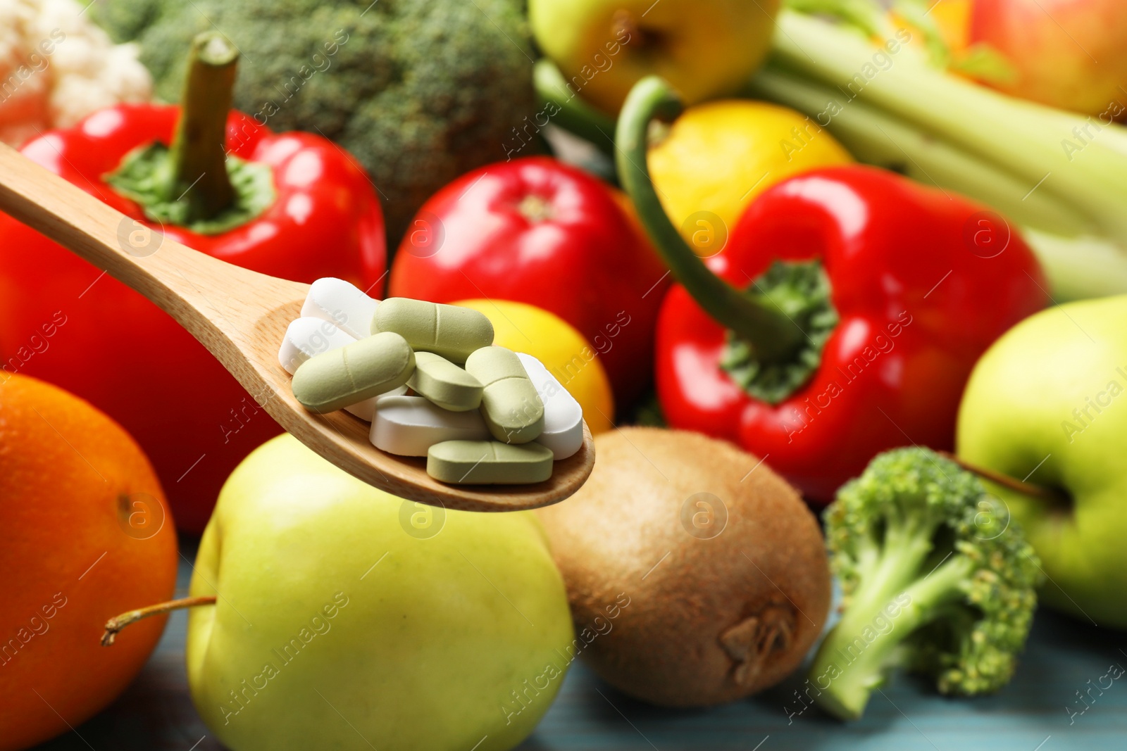 Photo of Dietary supplements. Spoon with different pills over food products, closeup