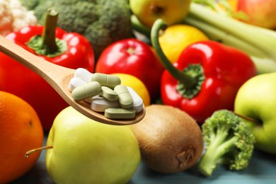 Photo of Dietary supplements. Spoon with different pills over food products, closeup