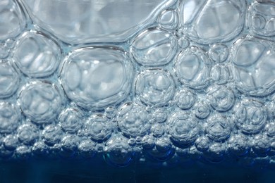 Photo of Texture of glass cleaning liquid with bubbles, macro view