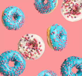 Set of falling delicious donuts on pink background