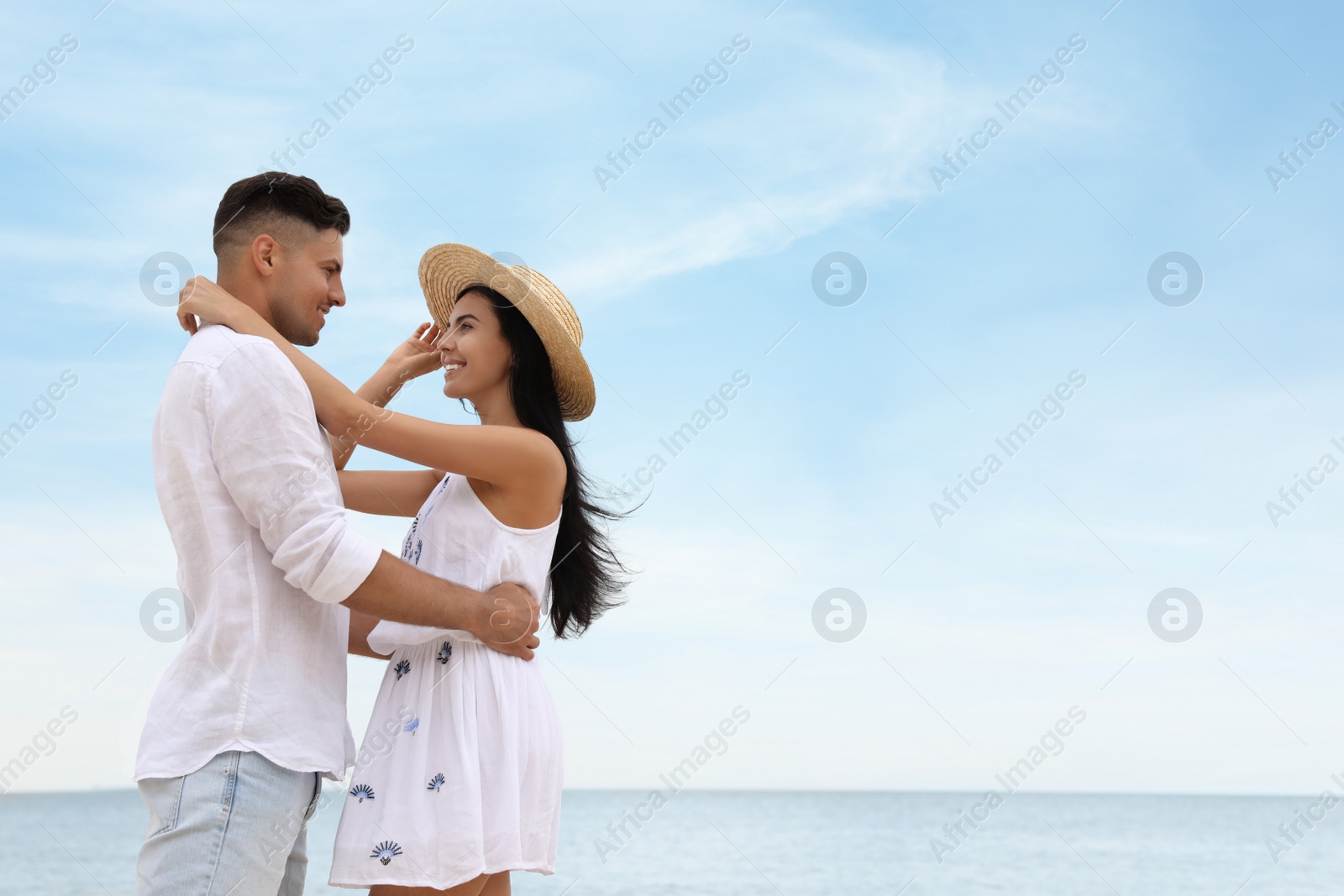 Photo of Lovely couple spending time together on beach near sea. Space for text