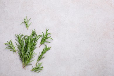 Sprigs of rosemary on light gray background, flat lay. Space for text