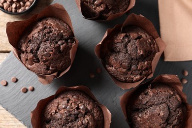 Delicious chocolate muffins on wooden table, top view