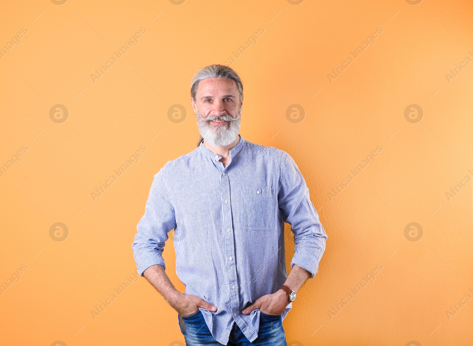 Photo of Portrait of handsome mature man on color background